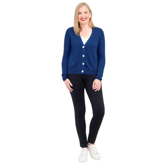 female model wearing jessica indigo blue button up cardigan sweater, reanna white tank top and nadia black pants front view on white background
