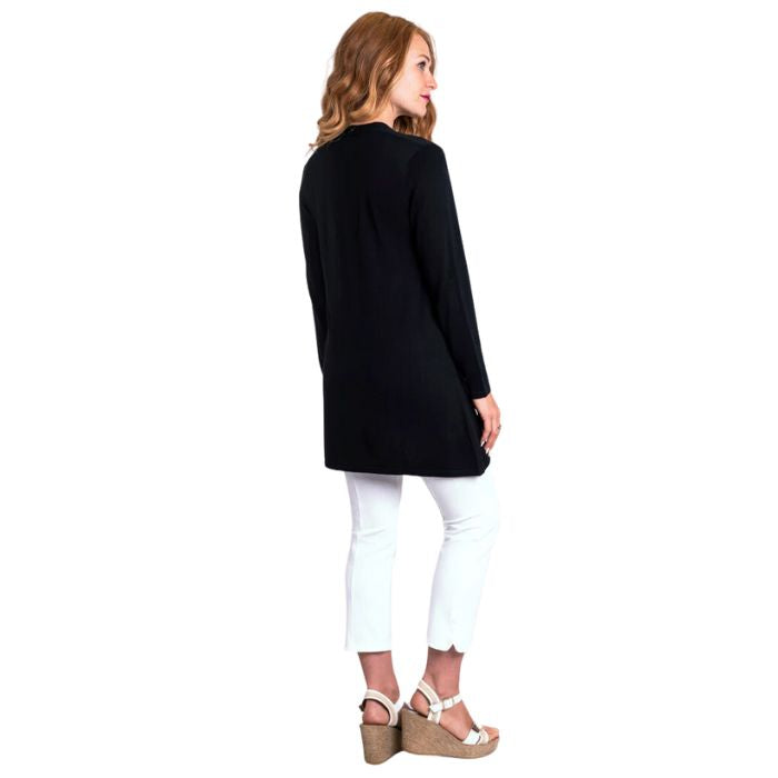 female model wearing justine black draped cardigan sweater and nadine white croppped pants back view on white background