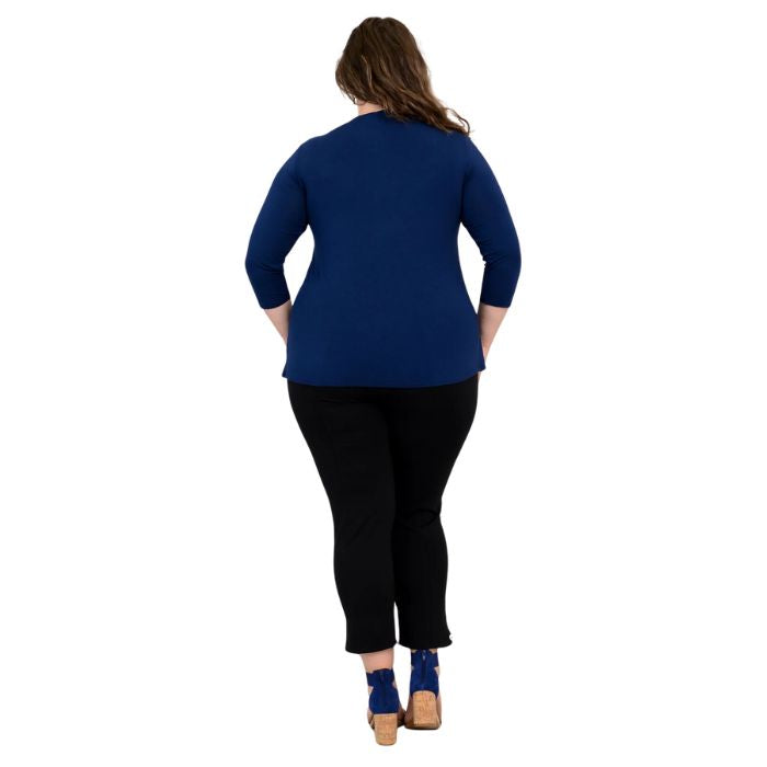female model wearing mia indigo blue three quarter sleeve top and nadine black cropped pants back view on white background