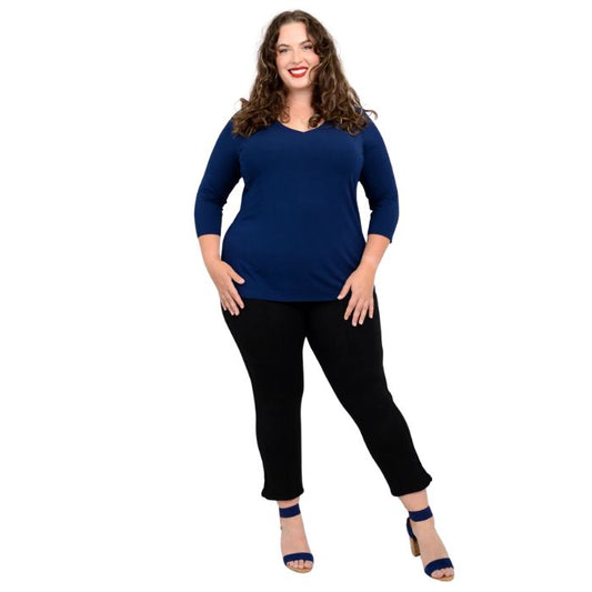 female model wearing mia indigo blue three quarter sleeve top and nadine black cropped pants front view on white background