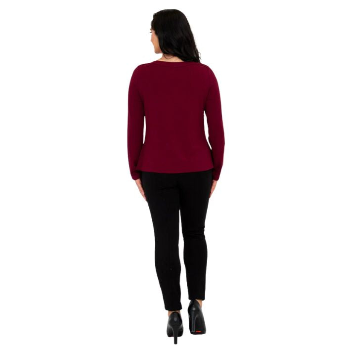 female model wearing mona burgundy red long sleeve top and nadia black pants back view on white background