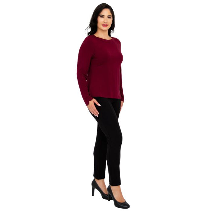 female model wearing mona burgundy red long sleeve top and nadia black pants side view on white background