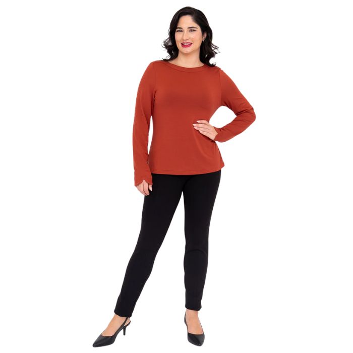 female model wearing mona cuprum orange long sleeve top and nadia black pants front view on white background
