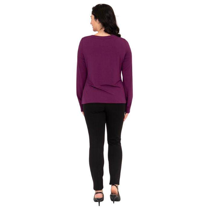 female model wearing mona magenta purple long sleeve top and nadia black pants back view on white background