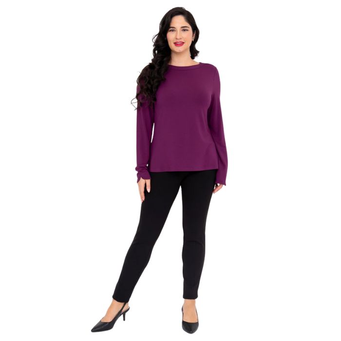 female model wearing mona magenta purple long sleeve top and nadia black pants front view on white background