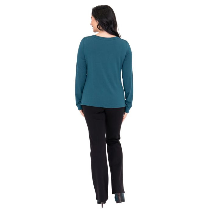 female model wearing mona teal green long sleeve top and daya black pants back view on white background