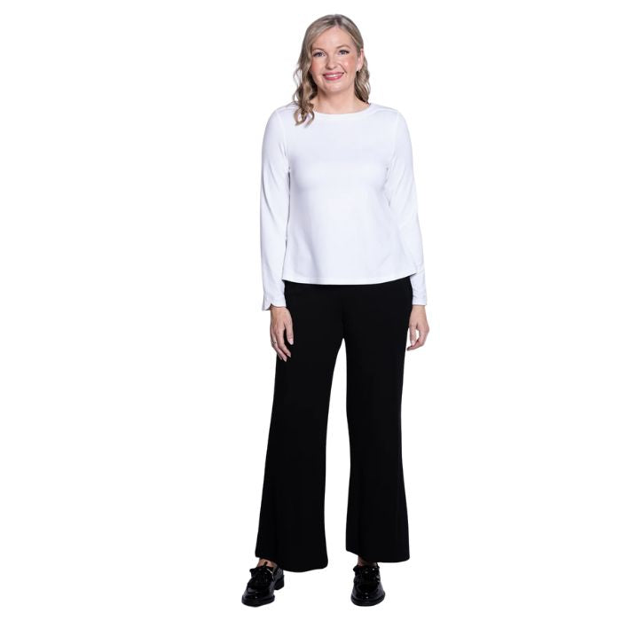 female model wearing mona white long sleeve top and daya black pants front view on white background