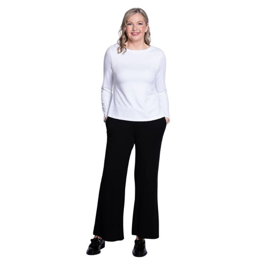 female model wearing mona white long sleeve top and daya black pants front view on white background