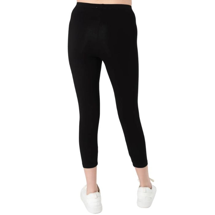 female model wearing black suri capri length leggings back view on white background
