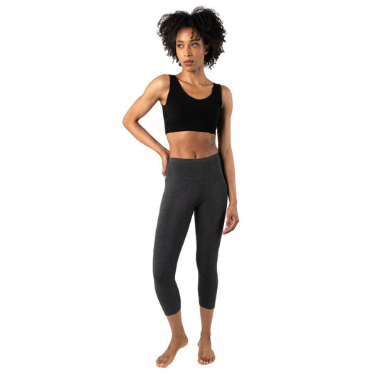 female model wearing charcoal grey suri capri length leggings and black terrera essential bralette front view on white background