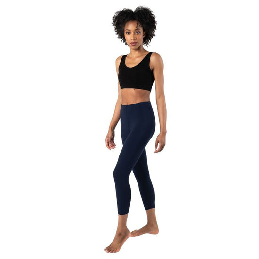 female model wearing ink blue suri capri length leggings and terrera essential bralette black front view on white background