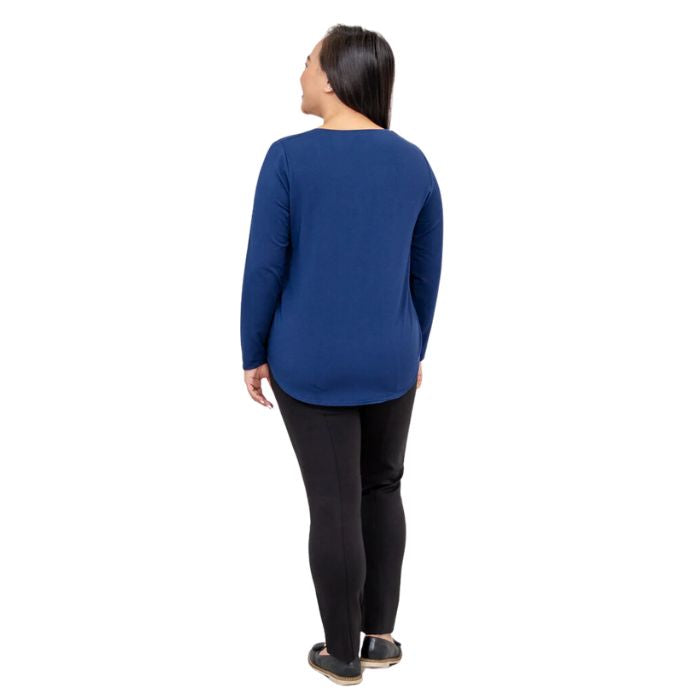 female model wearing tessa long sleeve top indigo blue and nadia black pants back view on white background