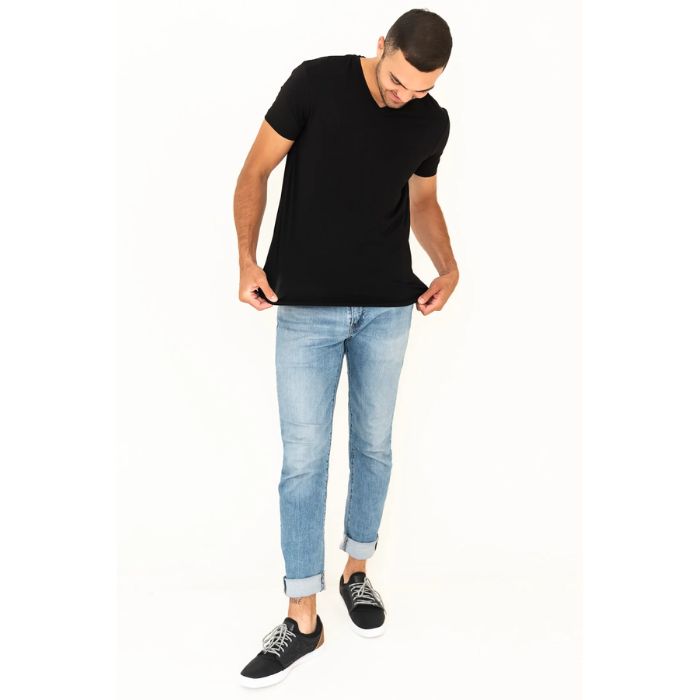 male model wearing black huron v-neck t-shirt and blue jeans front view on white background