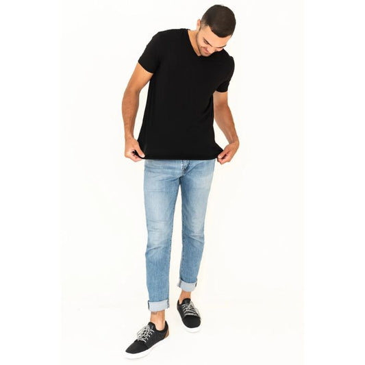 male model wearing black huron v-neck t-shirt and blue jeans front view on white background