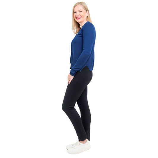 female model wearing jessica indigo blue button up cardigan sweater, reanna white tank top and nadia black pants side view on white background