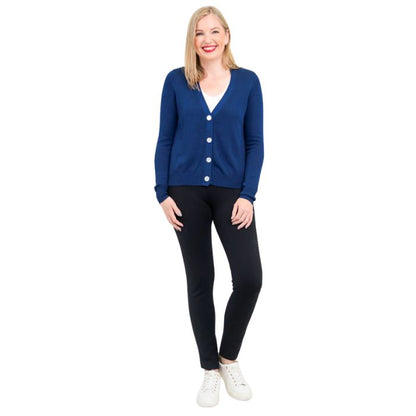 female model wearing jessica indigo blue button up cardigan sweater, reanna white tank top and nadia black pants front view on white background