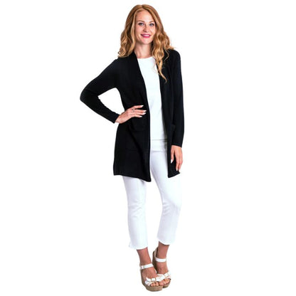 female model wearing justine black draped cardigan sweater and nadine white croppped pants front view on white background