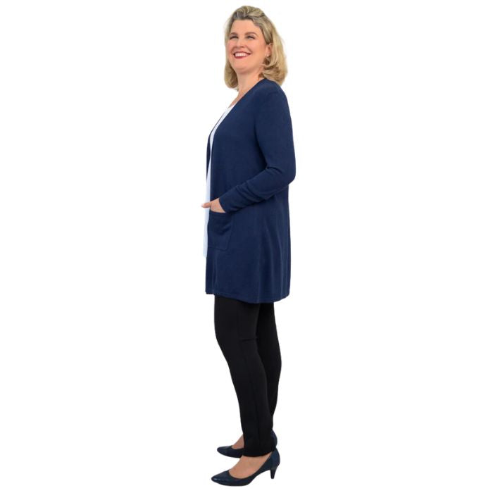 female model wearing indigo blue justine draped cardigan sweater, white jazz tank top and nlack nadia pants side view on white background
