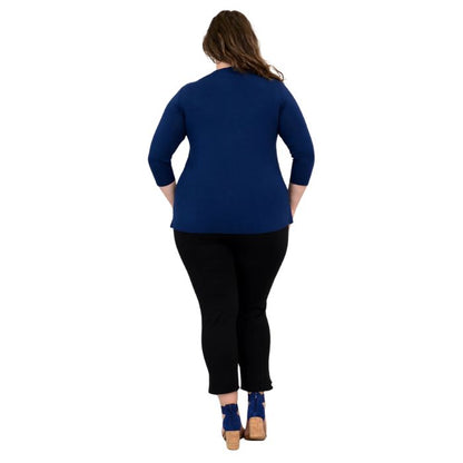 female model wearing mia indigo blue three quarter sleeve top and nadine black cropped pants back view on white background