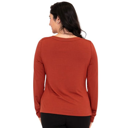 top of female model wearing mona cuprum orange long sleeve top back view on white background