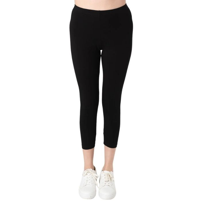 female model wearing black suri capri length leggings front view on white background 