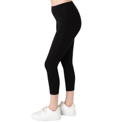 female model wearing black suri capri length leggings side view on white background 