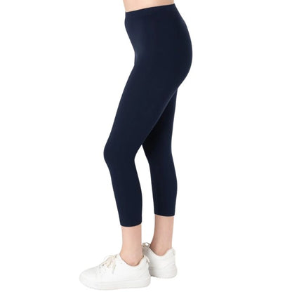 female model wearing ink blue suri capri length leggings side view on white background 